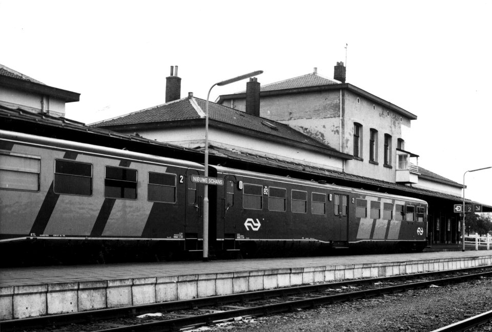 HUA-154997-Gezicht op de perronzijde van het NS station Nieuweschans te Nieuweschans met langs het perron het diesel electrische treinstel nr 82 DE 2 Blauwe Enge