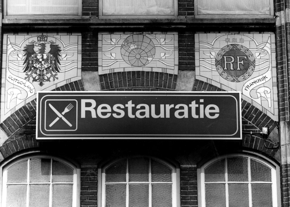 HUA-156152-Afbeelding van een tableau van sectieltegels aan de gevel van het NS station Roosendaal te Roosendaal voorstellende de wapenschilden van Duitsland en 