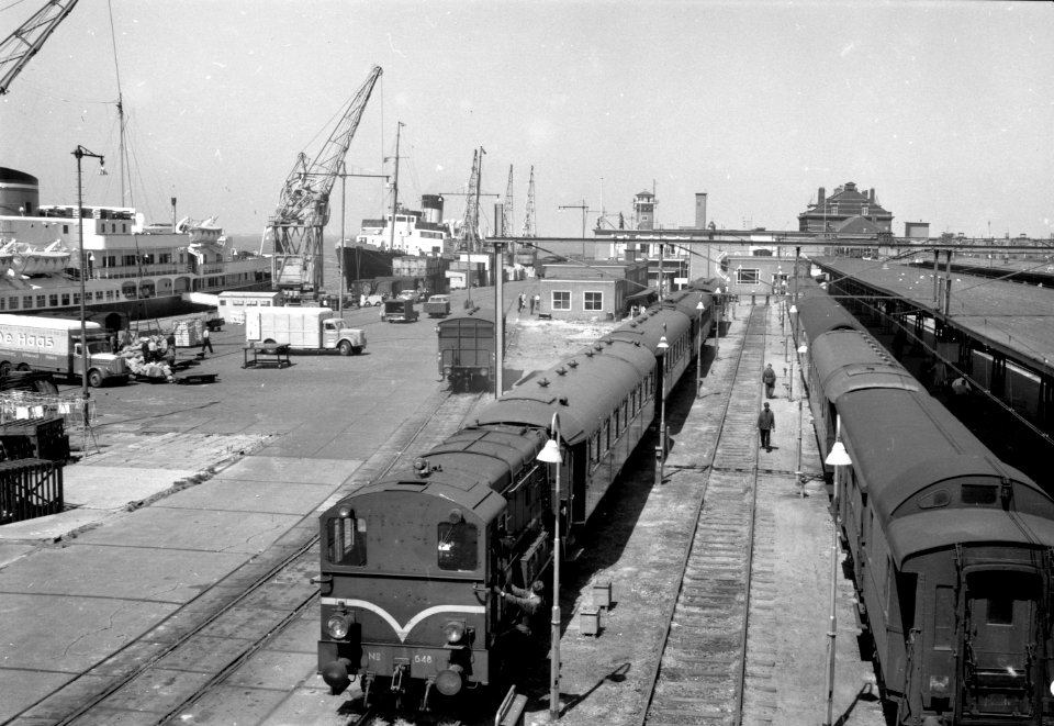 HUA-154990-Gezicht op het emplacement van het N.S.-station Hoek van Holland Haven te Hoek van Holland met de diesel-electrische rangeerlocomotief nr. 648 (serie 600) van de N.S. met rijtuigen
