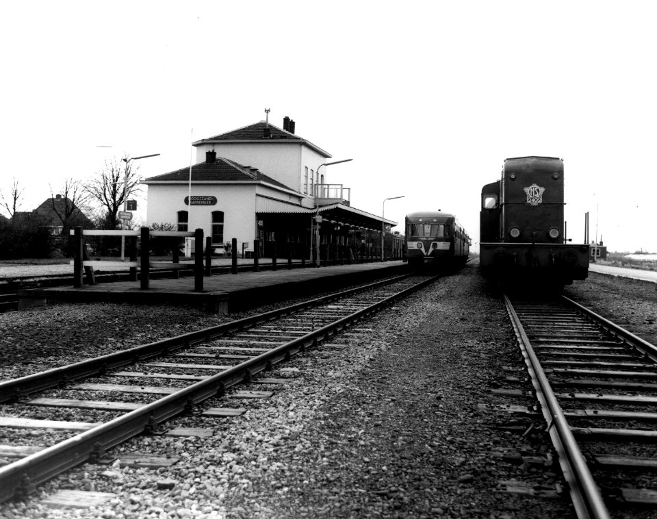 HUA-150451-Gezicht op het N.S.-station Hoogezand-Sappemeer te Hoogezand-Sappemeer, met langs het perron een diesel-electrisch treinstel DE 2 ("Blauwe Engel") en rechts de diesel-electrische locomotief nr. 2402 (