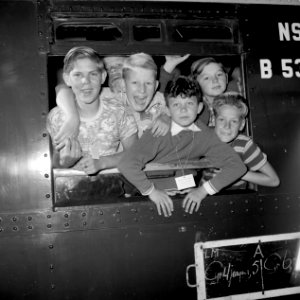 HUA-152948-Afbeelding van Groningse kinderen die uit het raam hangen van de Vakantie Kindertrein tijdens het Vakantie Kinderfeest op het N.S.-station Groningen te Groningen