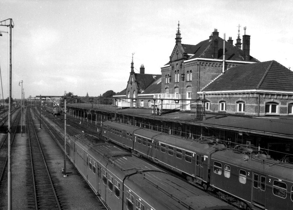 HUA-154840-Gezicht op het NS station Geldermalsen te Geldermalsen met een electrisch treinstel mat 1946 en het diesel electrische treinstel nr 152 DE 3 plan U va