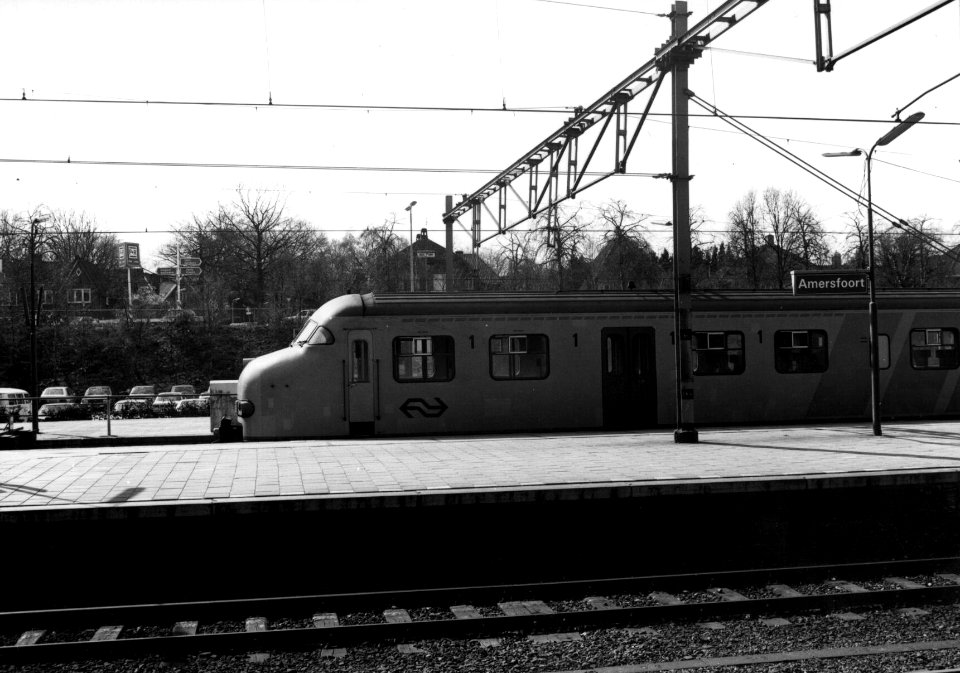 HUA-156299-Afbeelding van het electrische treinstel nr. 877 (mat. 1964, plan V) van de N.S. langs een perron van het N.S.-station Amersfoort te Amersfoort. Links op de achtergrond een deel van de P+R-parkeerplaa