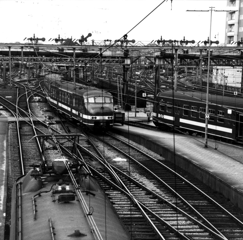 HUA-154818-Afbeelding van enkele electrische treinstellen van de NS mat 1964 en linksonder mat 1954 aan de westzijde van het NS station Amsterdam CS te Amsterdam