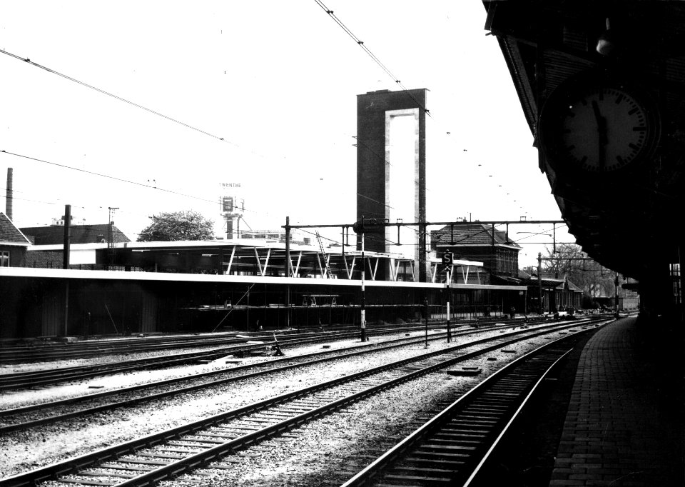 HUA-152998-Gezicht op het in aanbouw zijnde N.S.-station Almelo te Almelo vanaf het perron met op de achtergrond het oude stationsgebouw