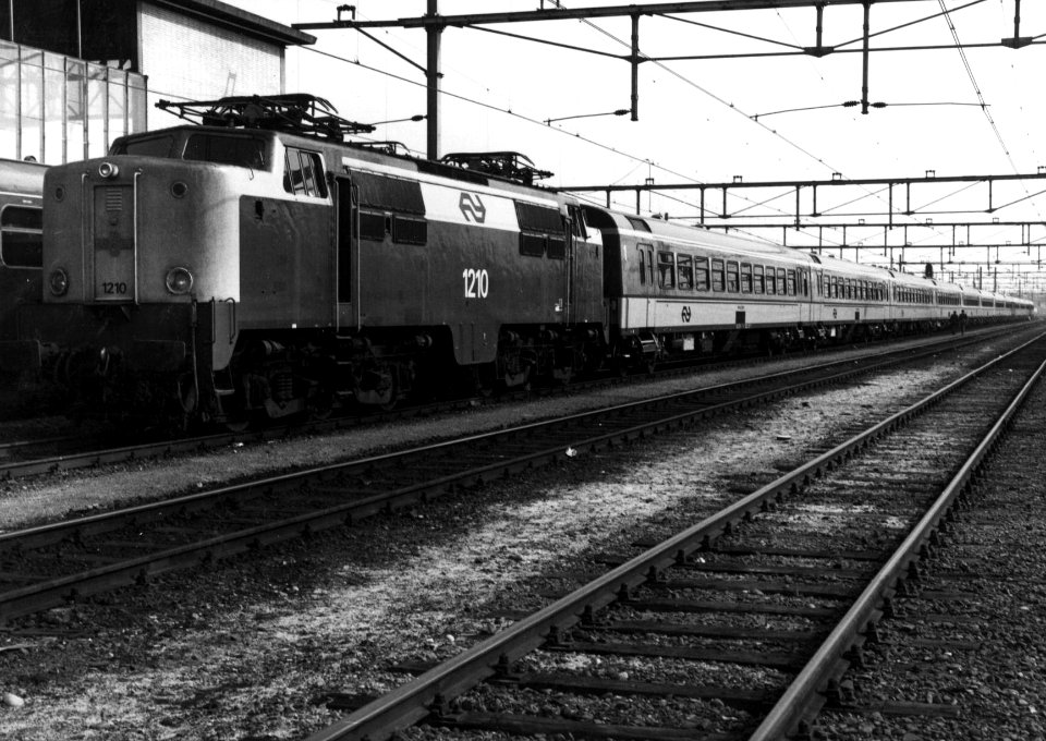 HUA-155034-Afbeelding van de electrische locomotief nr. 1210 (serie 1200) van de N.S. met ICR-rijtuigen bij het N.S.-station Eindhoven te Eindhoven