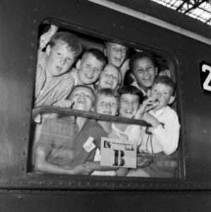 HUA-152958-Afbeelding van kinderen bij vertrek per trein uit het N.S.-station Amsterdam C.S. te Amsterdam (Groot Vakantie Kinderfeest)