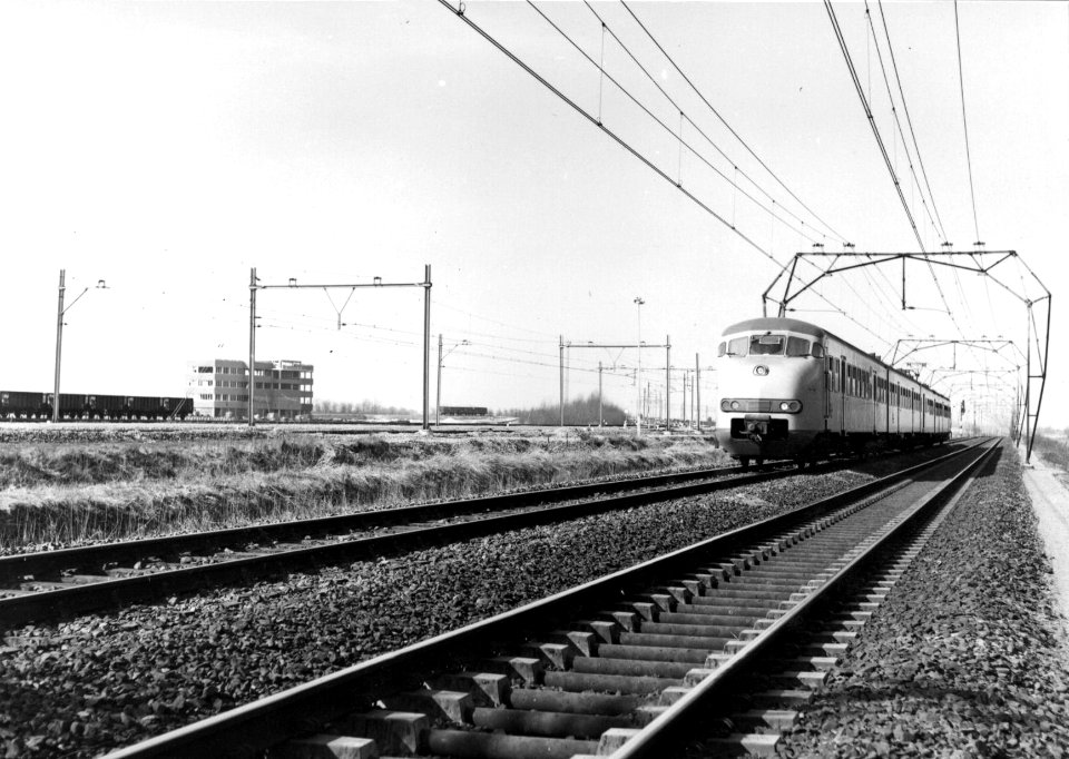 HUA-154887-Afbeelding van een electrisch treinstel met. 1964 (plan T) van de N.S. ter hoogte van het in aanbouw zijnde rangeerterrein Kijfhoek
