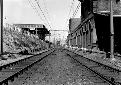 HUA-154639-Gezicht op het N.S.-station Leiden te Leiden met rechts het oude (lage) stationsgebouw en links het nieuwe, verhoogde perron met perronkap