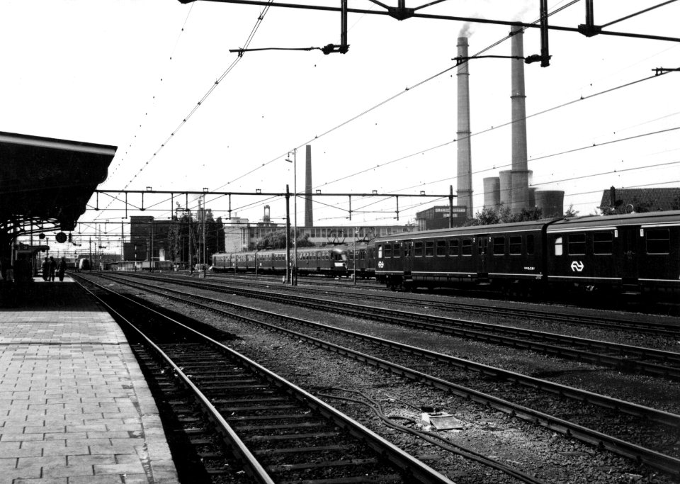 HUA-154852-Gezicht op het emplacement bij het N.S.-station Heerlen te Heerlen met rijtuigen plan E en electrische treinstellen mat. 1946 van de N.S. en op de achtergrond de Oranje Nassau-mijn