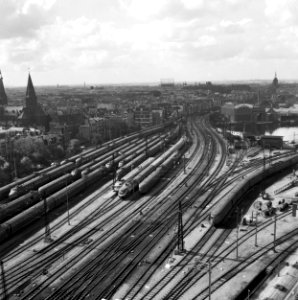 HUA-154799-Gezicht vanuit het havengebouw te Amsterdam op het emplacement aan de westzijde van het N.S.-station Amsterdam C.S. (Westelijk Eiland) met diverse soorten spoorwegmaterieel
