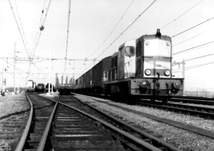 HUA-154889-Afbeelding van de diesel-electrische locomotief nr. 2441 (serie 2400-2500) van de N.S. met een goederentrein op het rangeerterrein Kijfhoek