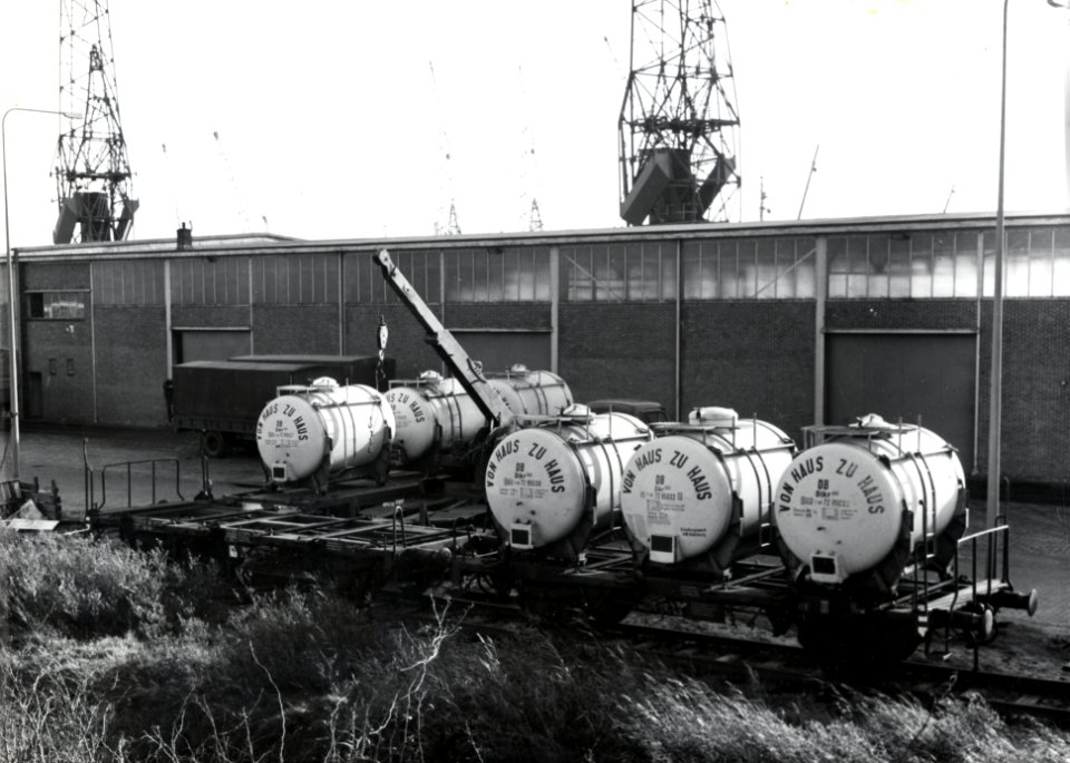 HUA-154127-Afbeelding van het vervoer van cacaoboter van Westzaan naar Amsterdam het beladen van de goederenwagens met laadkisten