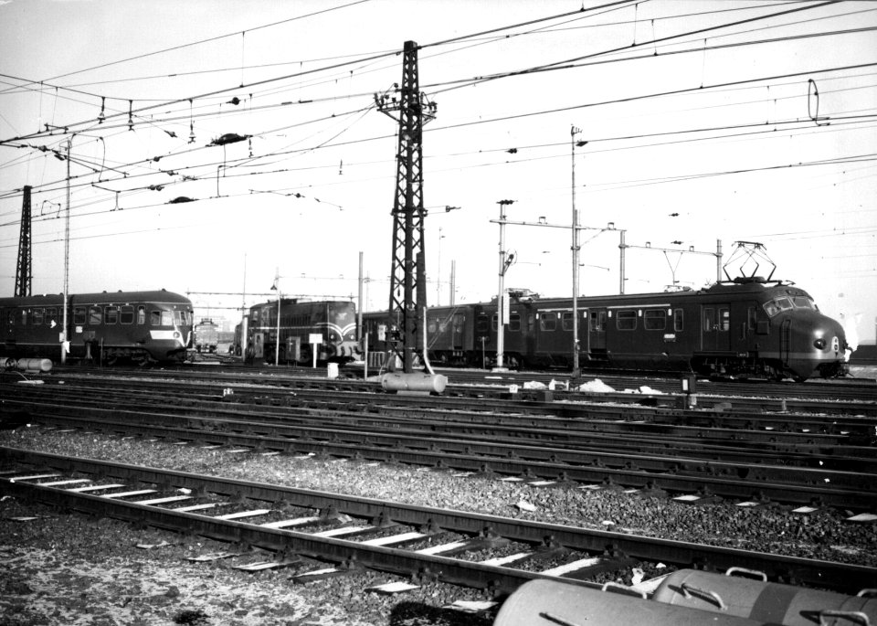 HUA-154813-Gezicht op het emplacement Westelijk Eiland aan de westzijde van het N.S.-station Amsterdam C.S. te Amsterdam met een diesel-electrisch treinstel DE 5 (serie 181-197, voorheen serie 51-68), een diesel