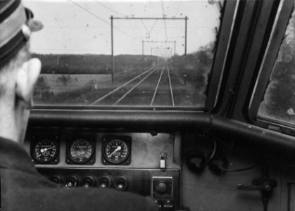 HUA-156328-Gezicht op de spoorbaan tussen Maarn en Utrecht over de schouder van een machinist in de stuurstand van een electrisch treinstel mat. 1954 van de N.S
