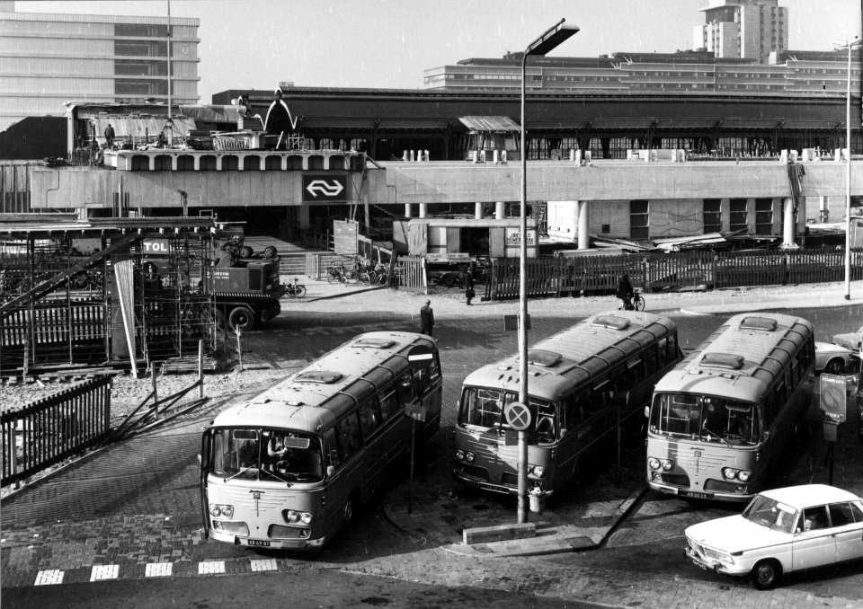 HUA-154529-Gezicht op het in aanbouw zijnde N.S.-station Utrecht C.S. te Utrecht aan het Stationsplein met op de voorgrond enkele autobussen