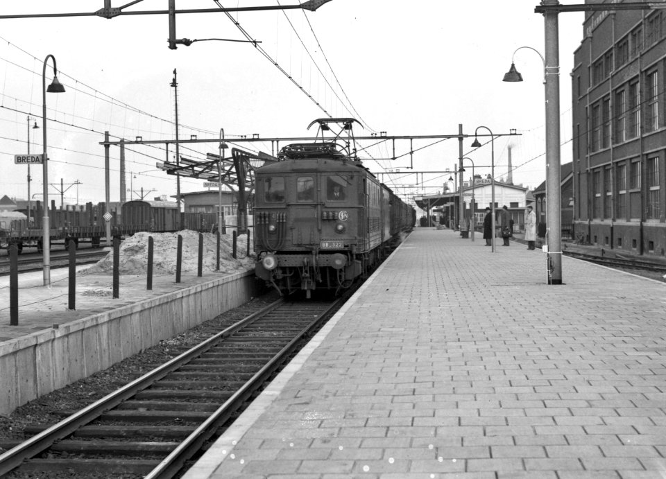 HUA-154602-Afbeelding van de door de N.S. gehuurde electrische locomotief BB 322 (serie BB 300) van de S.N.C.F. met rijtuigen langs het perron van het N.S.-station Breda te Breda