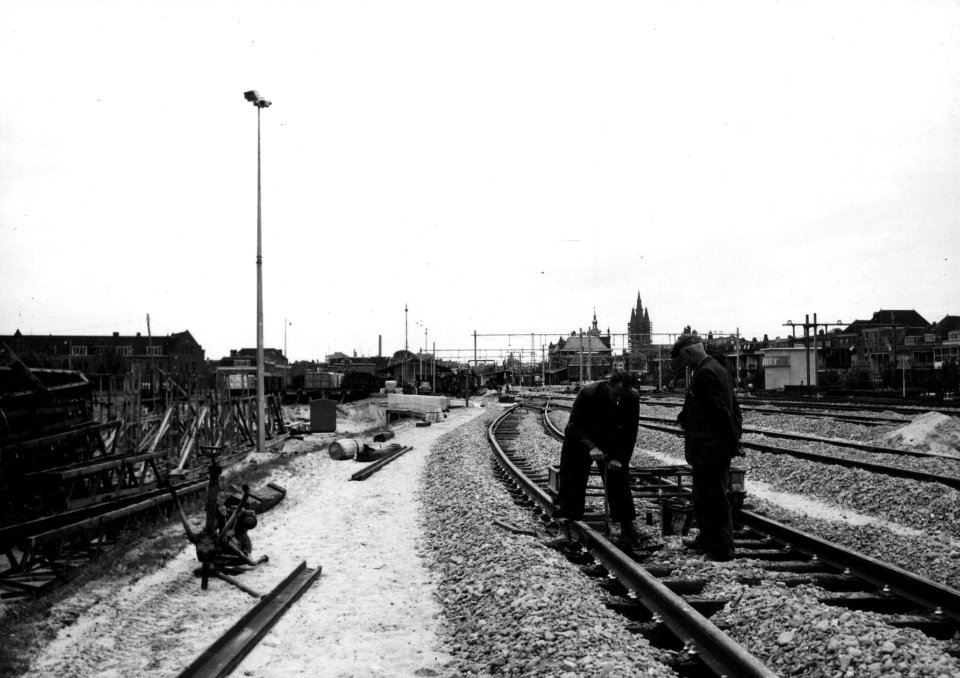 HUA-154282-Afbeelding van twee baanwerkers tijdens de werkzaamheden ten behoeve van de verhoging van de spoorlijn bij Delft