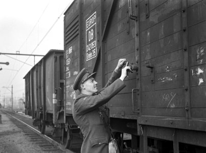 HUA-154254-Afbeelding van een douanier die een goederenwagen verzegelt na de grens controle op het emplacement te Roosendaal