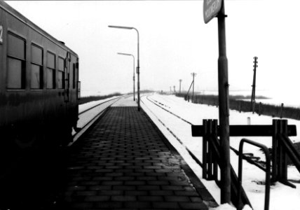 HUA-153152-Gezicht op het perron van het N.S.-station Koudum-Molkwerum te Koudum in een besneeuwd landschap, met links een diesel-electrisch treinstel DE 1 of DE 2 ("Blauwe Engel") van de N.S