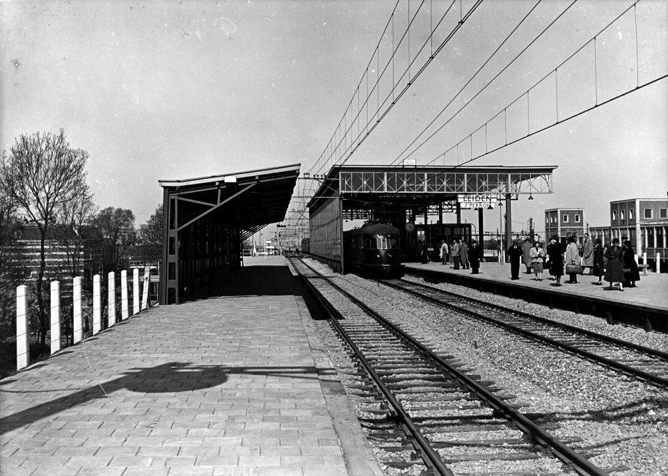 HUA-154640-Gezicht op het nieuwe (verhoogde) perron met perronkap van het N.S.-station Leiden te Leiden met een electrisch treinstel mat. 1940 van de N.S
