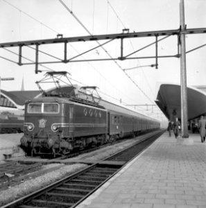HUA-155004-Afbeelding van de electrische locomotief nr. 1125 (serie 1100) van de N.S. met rijtuigen plan E langs een perron van het N.S.-station Rotterdam C.S. te Rotterdam