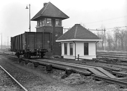 HUA-155276-Afbeelding van een goederenwagen op een spoor voorzien van railremmen op het rangeerterrein van de N.S. te Susteren met op de achtergrond het seinhuis