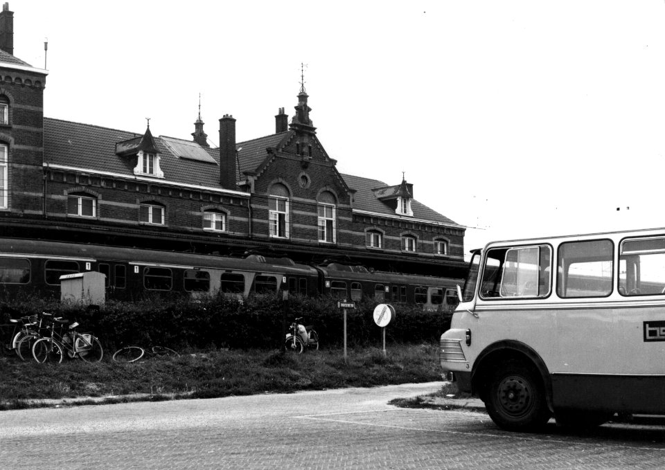 HUA-154207-Afbeelding van een autobus van de B.S.M. bij het N.S.-station Geldermalsen te Geldermalsen. Langs het perron staat een electrisch treinstel mat. 1946 van de N.S