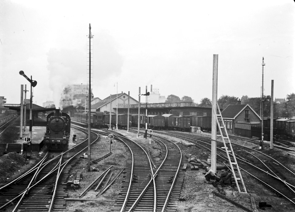 HUA-155236-Gezicht op het emplacement aan de oostzijde van het N.S.-station Groningen te Groningen ten tijde van de electrificatiewerkzaamheden. Links rijdt stoomlocomotief nr. 3736 (serie 3700-3800) van de N.S