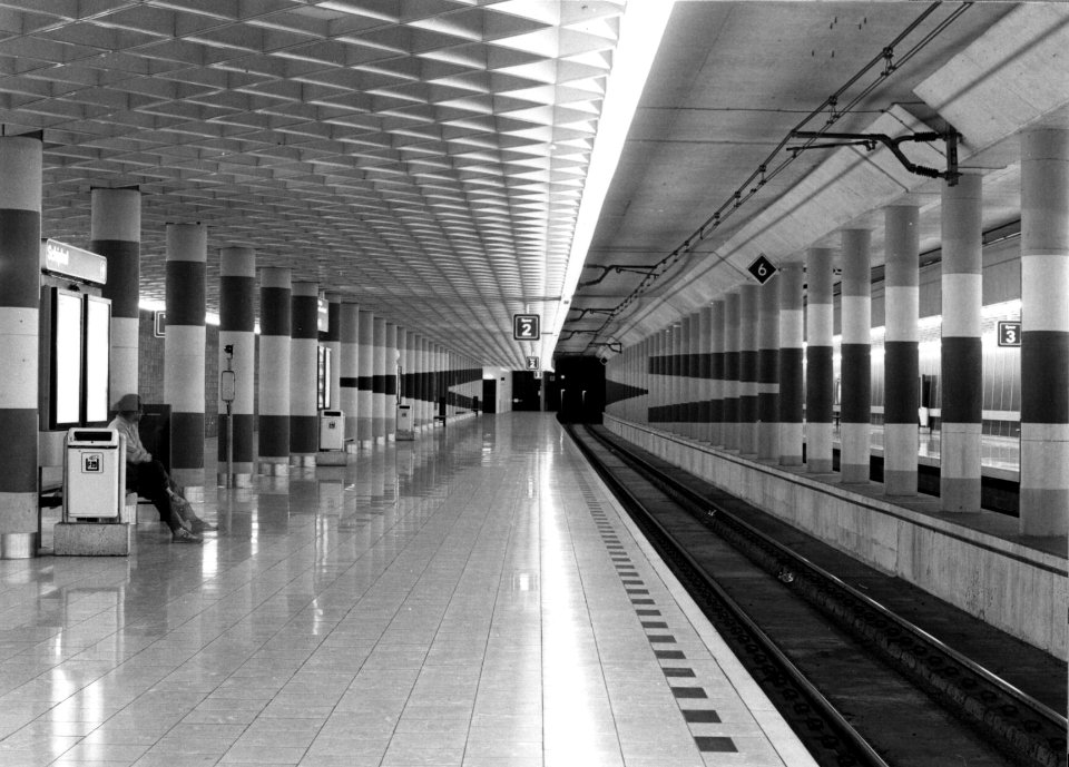 HUA-154066-Gezicht in de stationshal van het N.S.-station Schiphol te Amsterdam met de beschilderde kolommen van de kunstenaar M.J. Schwenke