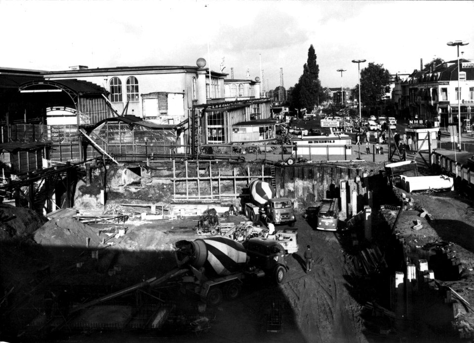 HUA-154451-Gezicht op de bouwput voor het nieuwe Centraal Station te Utrecht met op de achtergrond het oude N.S.-station Utrecht C.S. en het Stationsplein