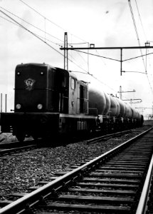 HUA-154310-Afbeelding van de diesel electrische locomotief nr 2407 serie 2400 2500 van de NS met een goederentrein bestaande uit silowagens te Zaandam