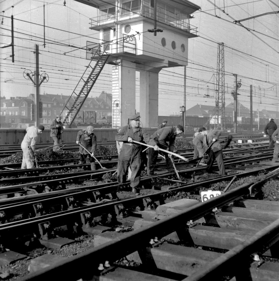 HUA-154286-Afbeelding van wegwerkers tijdens onderhoudswerkzaamheden op het emplacement te Maastricht Op de achtergrond het seinhuis Post T