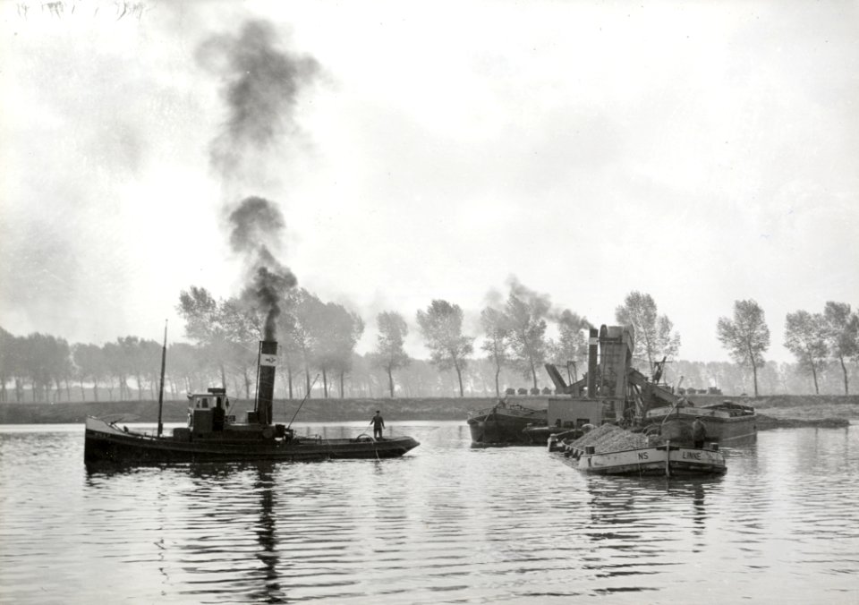 HUA-154242-Afbeelding van een baggermolen voor het baggeren van grind en een sleepboot van de N.S. bij Grinderij Linne te Linne