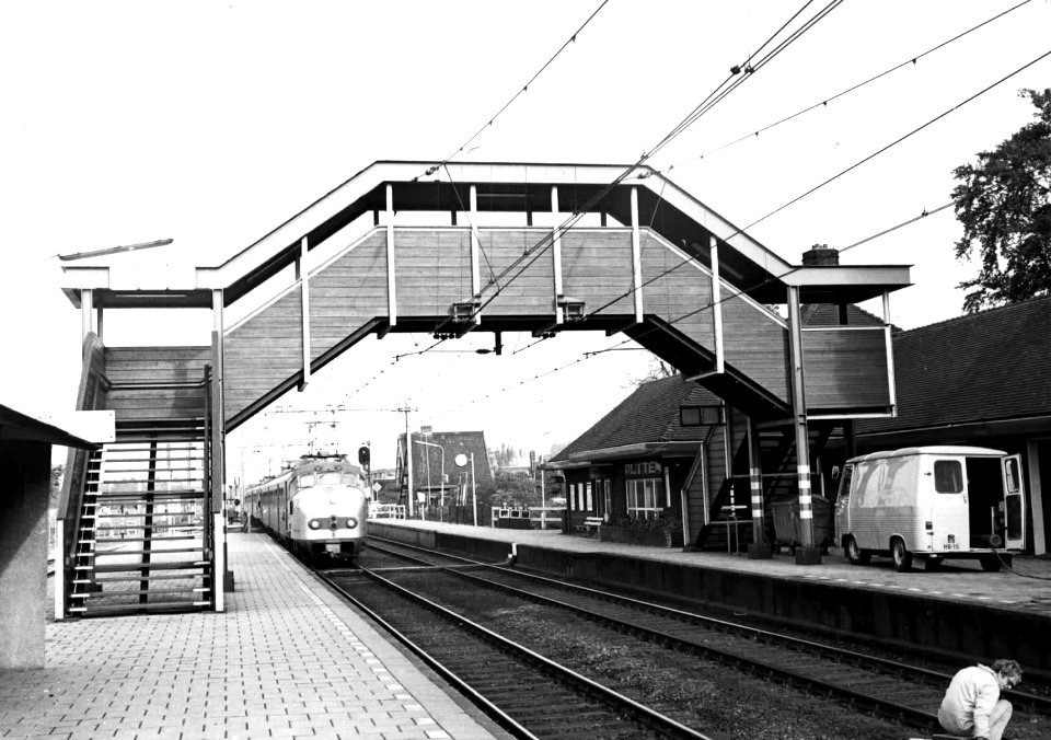 HUA-150589-Gezicht op perrons en de voetgangersbrug van het N.S.-station Putten te Putten, met een naderende trein bestaande uit electrische treinstellen mat. 1954