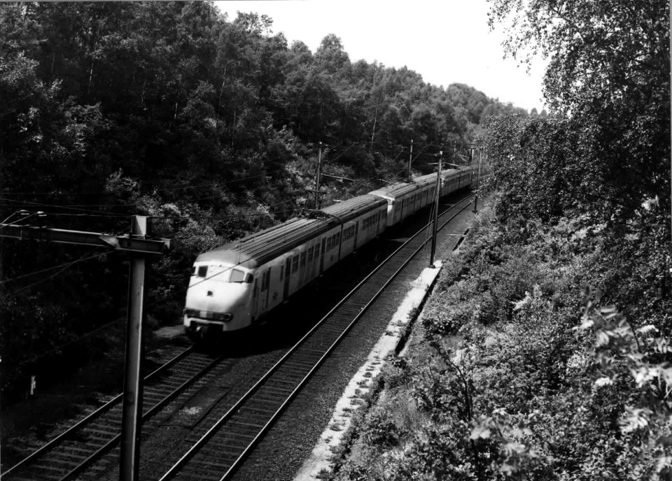 HUA-151056-Afbeelding van drie gekoppelde electrische treinstellen mat. 1964 (plan V) van de N.S. gezien vanaf het viaduct van de Schelmseweg te Oosterbeek