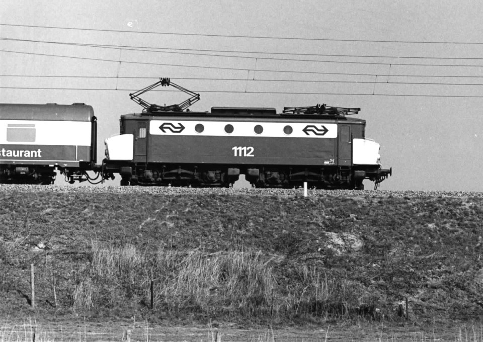 HUA-151141-Afbeelding van de electrische locomotief nr 1112 (serie 1100) van de N.S met internationale rijtuigen op de spoordijk nabij Culemborg