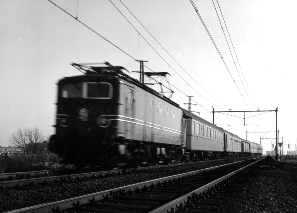 HUA-151114-Afbeelding van een electrische locomotief uit de serie 1100 met rijtuigen van de NS ter hoogte van Arnhem baanvak Arnhem Zevenaar 