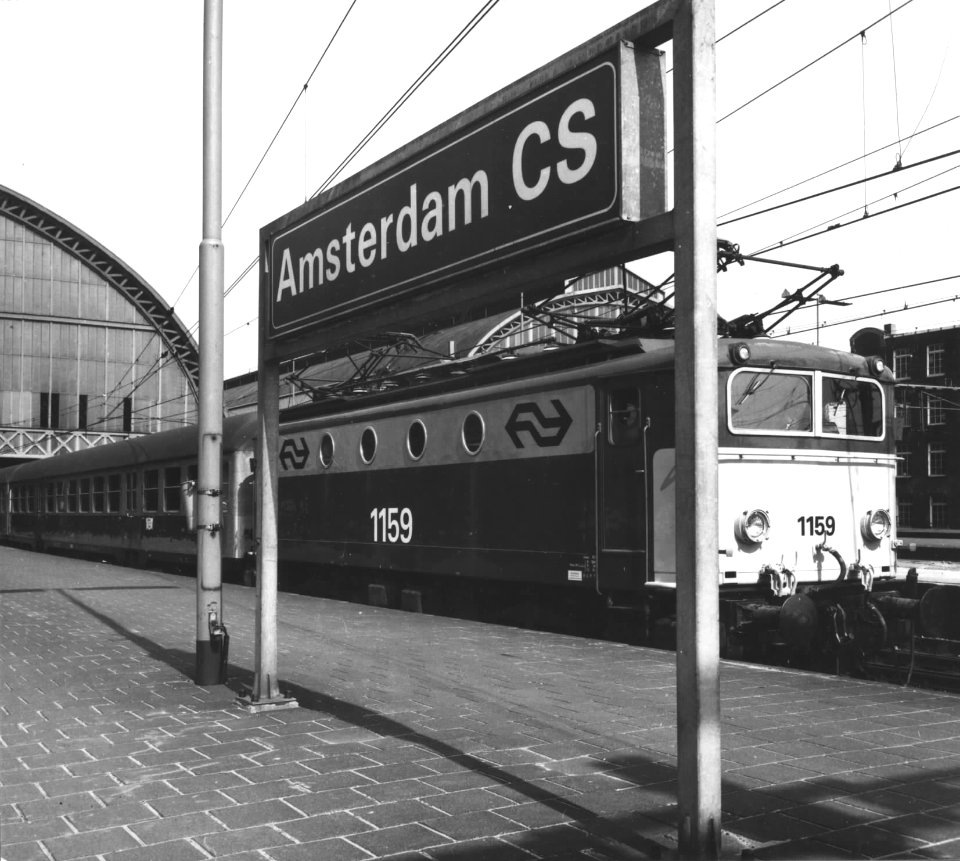 HUA-151135-Afbeelding van de electrische locomotief nr 1159 serie 1100 van de NS met internationale rijtuigen langs het perron Amsterdam CS te Amsterdam