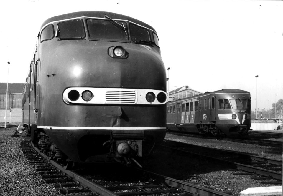 HUA-151217-Afbeelding van een diesel-electrisch treinstel DE 3 (serie 111-152-plan U) met op de achtergrond een diesel-electrisch treinstel DE 1 of DE 2 (Blauwe Engel) van de N.S. bij de werkplaats te Zwolle