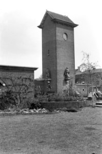 HUA-150606-Gezicht op de toren van het ketelhuis van het N.S.-station Roosendaal te Roosendaal, met door Jo Uiterwaal vervaardigde beelden