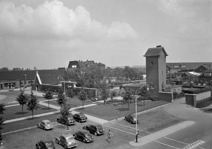HUA-150603-Gezicht op de rijwielstalling, toegangspoort tot het goederenstation en ketelhuis met toren bij het N.S.-station Roosendaal te Roosendaal