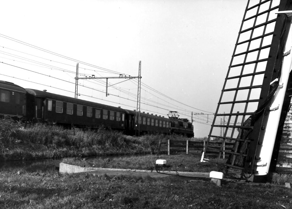 HUA-151054-Afbeelding van een electrische locomotief (serie 1200) van de N.S. met internationale rijtuigen bij de Lageveensemolen in Lisse