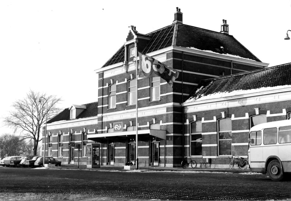 HUA-150683-Gezicht op het N.S.-station Sneek te Sneek met een vlag t.b.v. de promotie van de 65+ kaart