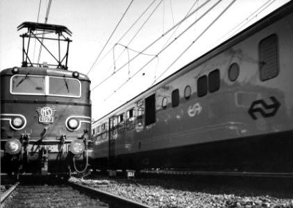 HUA-151221-Afbeelding van een gedeelte van het diesel-electrische treinstel DE 3 (serie 111-152-plan U) en de voorkant van de electrische locomotief nr. 1127 (serie 1100) van de N.S. op het emplacement te Arnhem