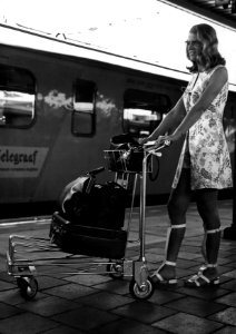 HUA-152031-Afbeelding van een vrouw met een witkar voor het vervoer van bagage op een perron van het N.S.-station Utrecht C.S