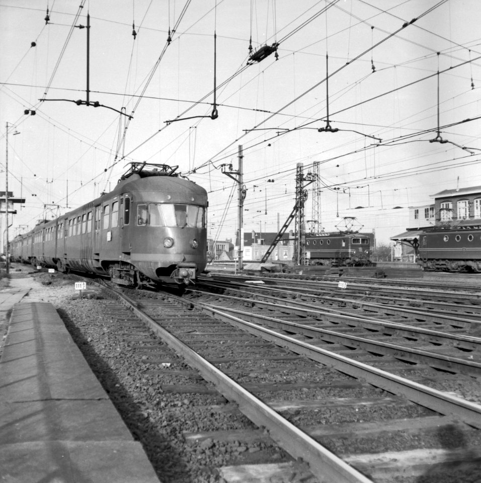 HUA-150930-Afbeelding van een electrisch treinstel mat. 1946 van de N.S. aan de noordzijde van het Centraal Station te Utrecht. Rechts staan twee electrische locomotieven uit de serie 1100