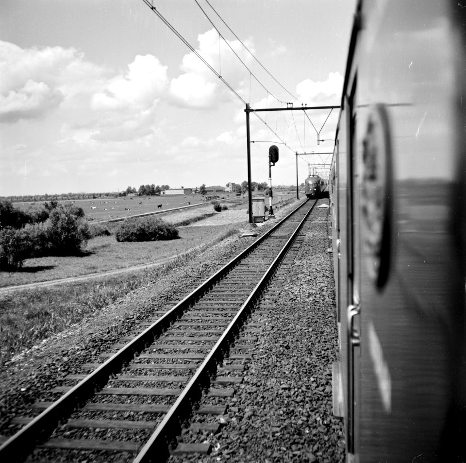 HUA-150955-Gezicht vanuit een rijdende trein op de spoorbaan (Utrecht-Gouda?) met een tegemoetkomende trein bestaande uit electrische treinstellen mat. 1946 van de N.S