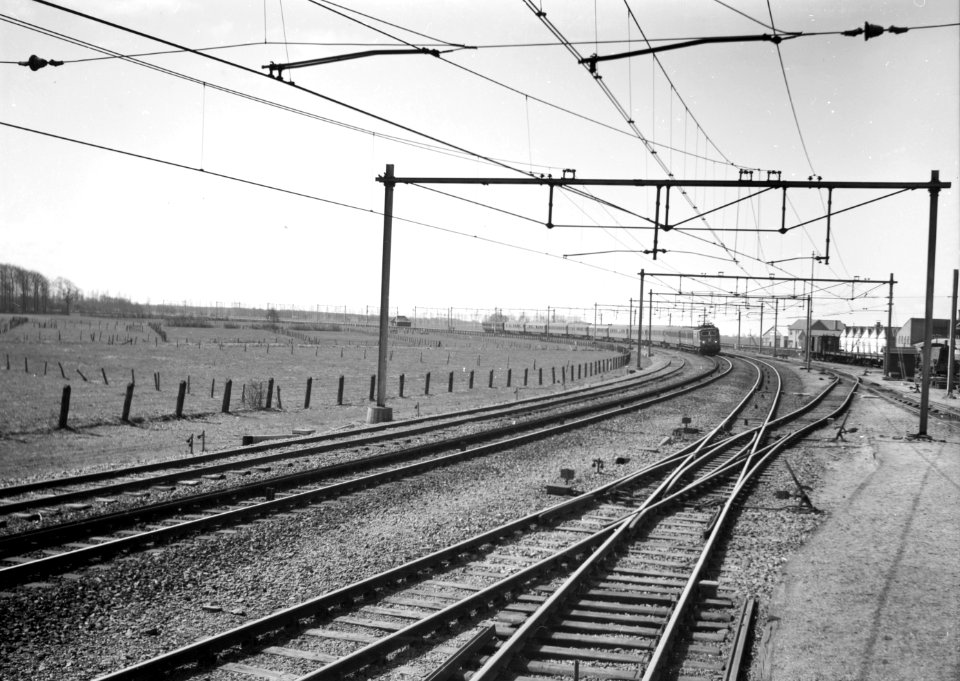 HUA-150911-Afbeelding van een electrische locomotief uit de serie 1100 van de N.S. met rijtuigen ter hoogte van Gouda