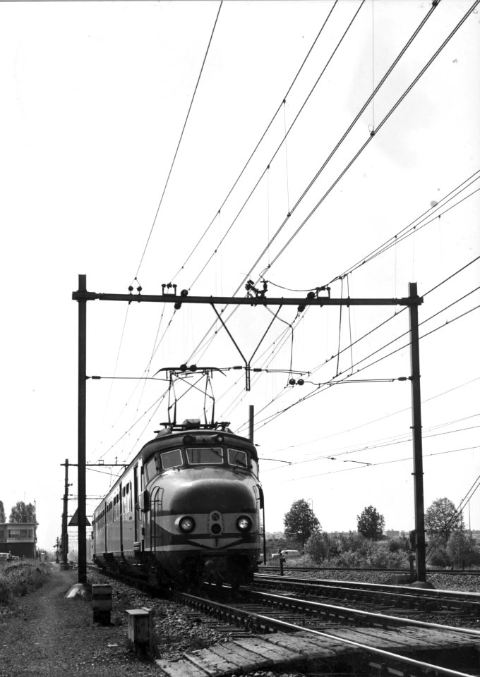 HUA-150974-Afbeelding van een electrisch treinstel mat. 1954 (plan F, G of M) van de N.S. na het passeren van de bewaakte overweg bij de treindienstleiderspost Blauwkapel (post T) te Utrecht